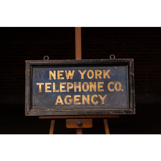 An early 20th-century double-sided advertising sign produced for a New York Telephone Company agency. Designed to hang in...