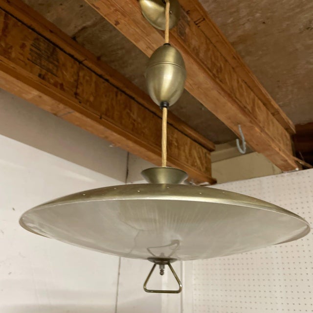 Vintage 1950s–60s Mid-Century Modern pull-down saucer pendant light. Features an 18" perforated brass/gold-tone metal...