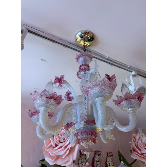 Elegant vintage Murano glass chandelier featuring hand-blown clear glass arms accented with delicate blush-pink floral...