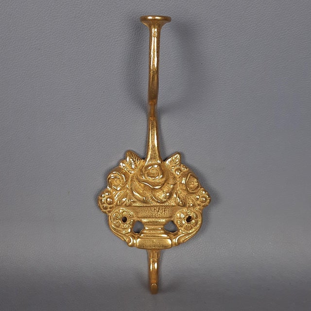 A refined set of 4 brass coat hooks (wall hooks). These pieces are a superb example of Lombard craftsmanship, finely...