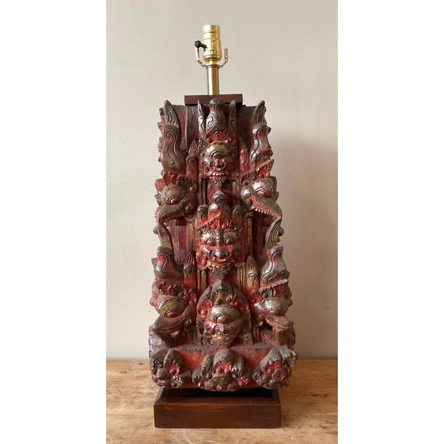 This powerful and intricate vintage table lamp is a masterpiece of hand-carved folk art. Featuring a complex, multi-faced...