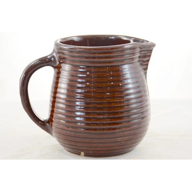 Vintage, warm brown, rustic farmhouse ribbed stoneware pitcher, circa 1930. Marked with an embossed Maple Leaf with a “W,...