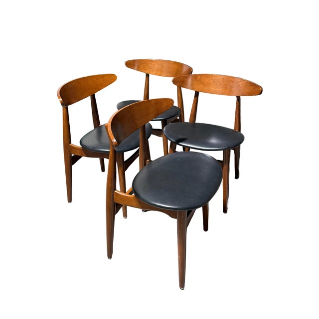 Set of 4 fantastic vintage Danish Greta dining chairs. The seats are covered with black leather with a thin stylized back....