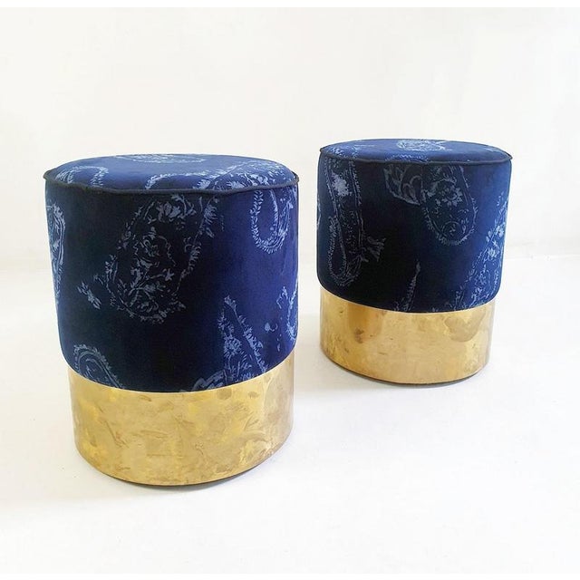 These particular poufs are handmade in Italy and upholstered with a paisley printed blue velvet and have a finishing rim...