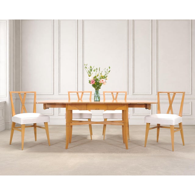 A rare mid-century modern drop-leaf expanding "Danbury" bleached mahogany dining table designed by Tommi Parzinger...