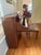 Beautiful vintage Baldwin upright piano with a warm walnut-toned wood cabinet, elegant curved profile, tapered legs, and...