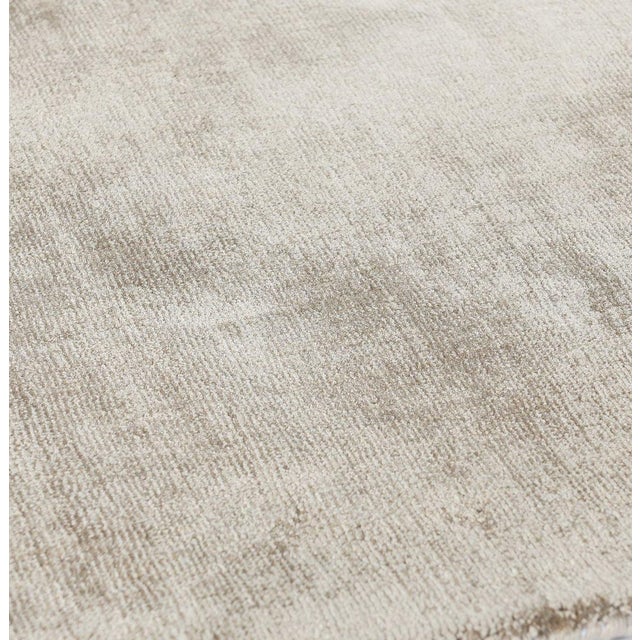 Soft luxurious sandy beige silk-like viscose-cotton rug. Lightly distressed finish for texture and dimension. Available in...