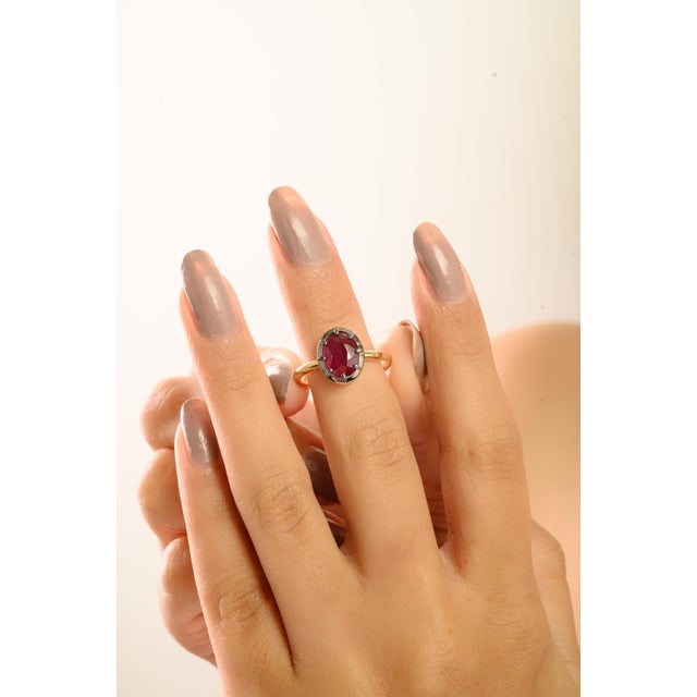 This solitaire ring showcases a stunning oval-cut red ruby weighing approximately 2.09 carats, beautifully set in...