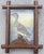 Behind a typical Tramp Art frame is a box. On the back of the box is a gouache painting of a half duck in profile style....