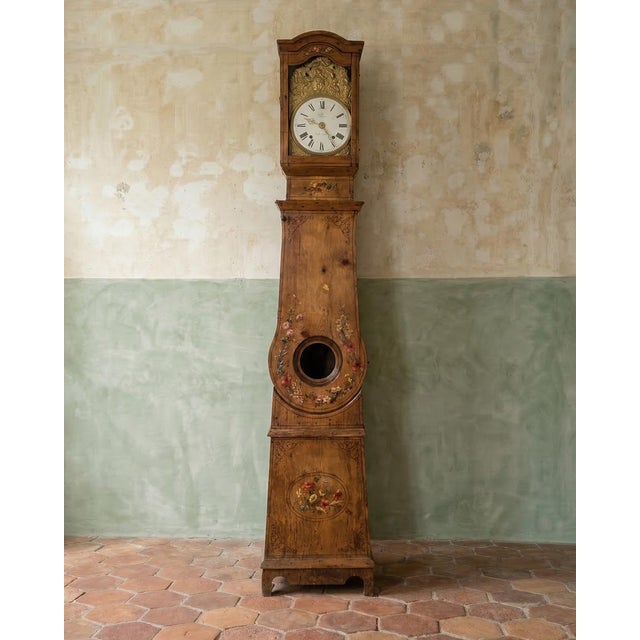 Charming French tall case clock featuring a painted pine case adorned with floral decorations. The porcelain clock dial...