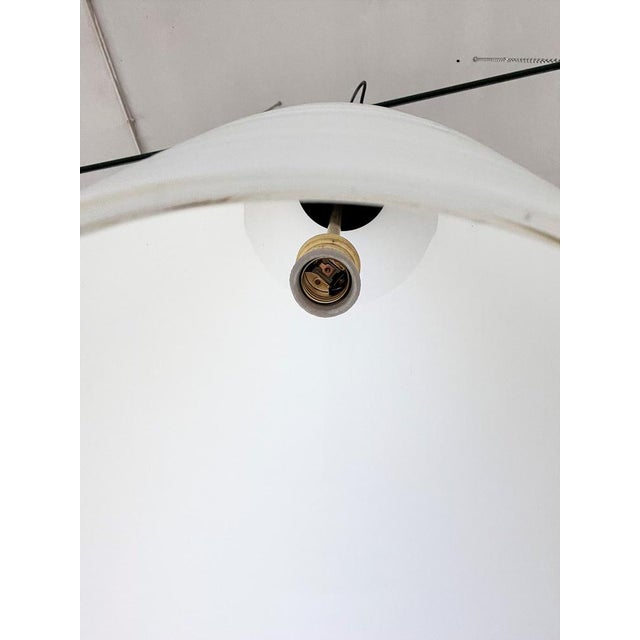 Gorgeous and long pendant light in milk white satinazed glass and brass and black metal details. The size of the only long...