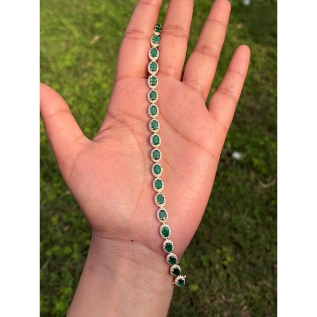 This tennis bracelet features a 8.55 carat oval-cut emeralds, set in 18K yellow gold. Each measuring around 6 x 4 mm and...