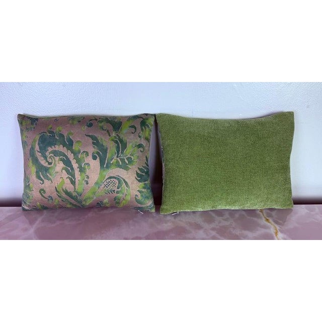 A refined pair of decorative pillows crafted from authentic Fortuny textile, featuring a richly layered scrolling foliate...