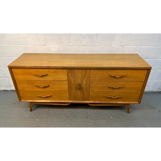 Striking mid-century modern lowboy dresser with iconic sculpted drawer pulls and tapered legs. Features six spacious...