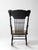 Early 20th century Art Nouveau rocking chair featuring a carved crest rail with flowing botanical motifs, turned spindle...
