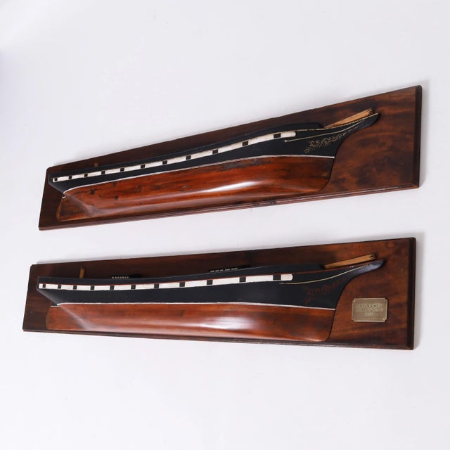 Impressive pair of mirror image antique half hull models crafted in pine, paint decorated, and faithfully rendered in form...