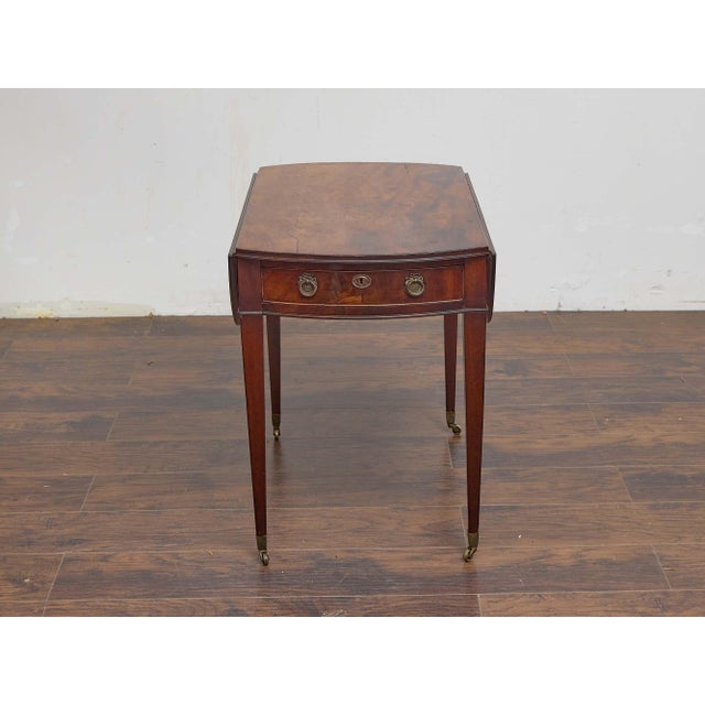 This English mahogany Pembroke table from the 19th century is a refined example of functional elegance. The top is crafted...