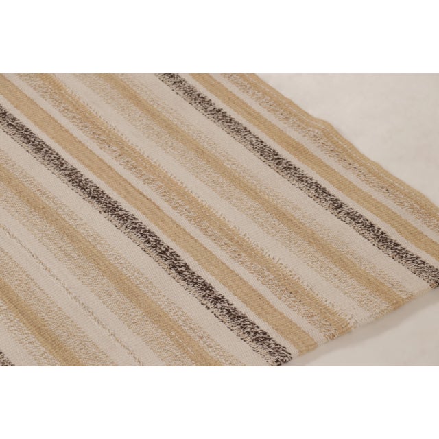 Handwoven in wool, this 5x6 Rez Kilim features an elegant arrangement of finely spaced stripes in soft ivory, taupe,...