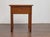 A French walnut side table from the 19th century, combining simple lines with refined carved details. The square top rests...