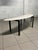Rare and particular 1950s coffee table of Italian manufacture, with black painted tubular iron structure and brass feet....