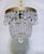 Add a touch of timeless, romantic glamour to your space with this exquisite vintage mid-century tiered brass crystal...