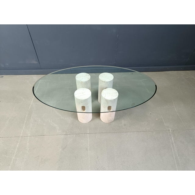 Vintage coffee table consisting of 4 travertine cillindres and an oval clear glass top. Timeless and very attractive...