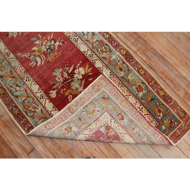 Early 20th century red field Turkish runner with an all-over repetitive flower design on a red field. The border is in...