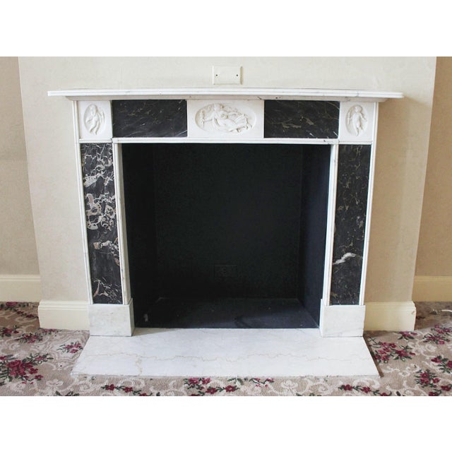 This English Regency style mantel is carved from statuary marble and inlaid with black and gold Portoro marble. In the...
