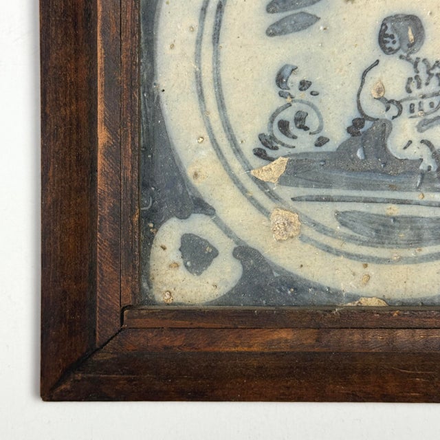 This 18th-century Portuguese azulejos tile features a hand-painted blue on white figurative vignette. It is framed in a...