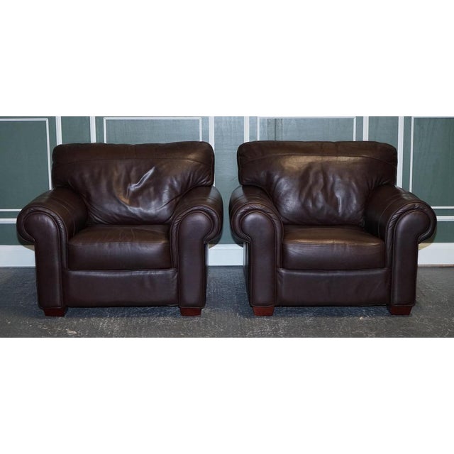 Pair of large comfortable brown leather armchairs. A good honest comfortable pair of armchairs. They are upholstered with...