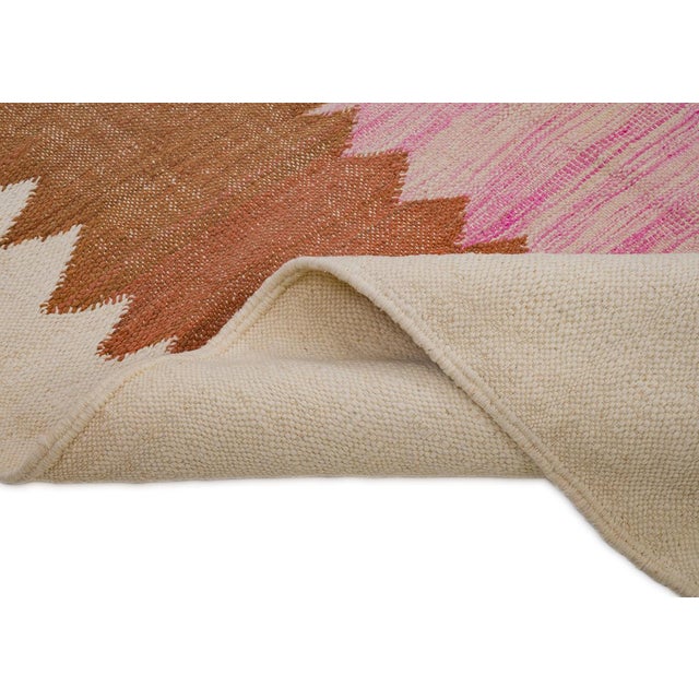 Modern handwoven wool rug featuring bold zigzag patterns in Mustard Yellow, Rust Brown, Burnt Orange, and Blush Pink on an...