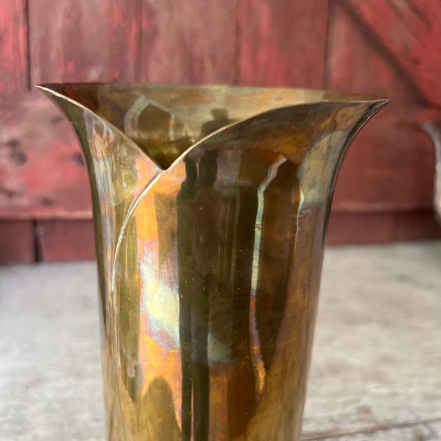 This vintage brass vase from India features a unique fluted design and a rich patina that adds character. Its tall, slim...
