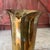 This vintage brass vase from India features a unique fluted design and a rich patina that adds character. Its tall, slim...