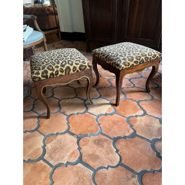 Pair of newly upholstered leopard footstools/ ottomans. Lee Jofa leopard print. Wood frames with gilded details.
