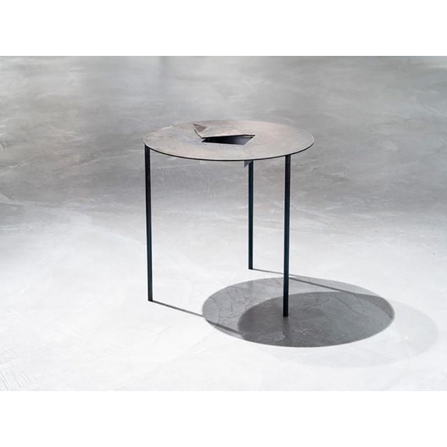 A table containing a silent double bottom, visible only through an unexpected cut. The dream is enclosed, protected, and...