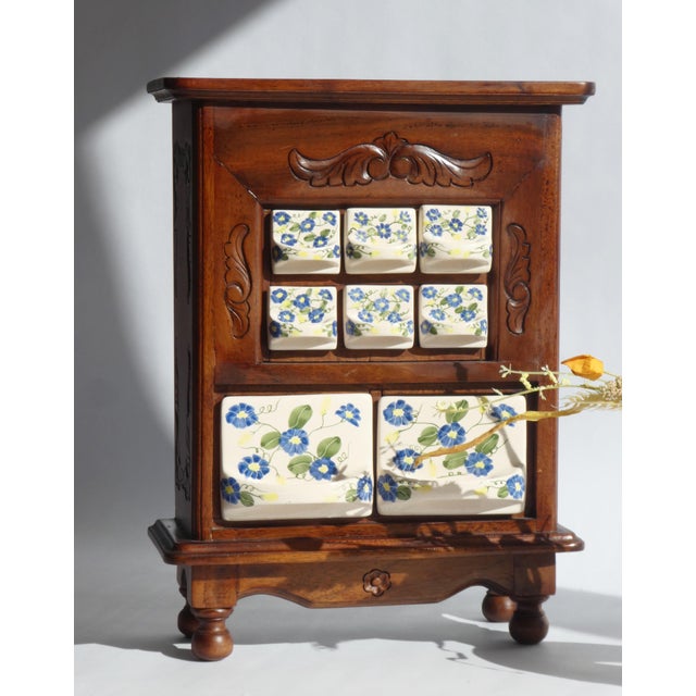 An antique wooden spice cabinet made in the Netherlands. The beautiful kitchen cabinet has 8 ceramic drawers with hand...