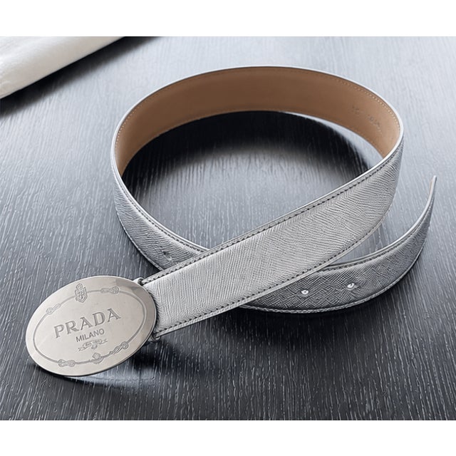 An elegant, chic vintage Prada belt crafted in the house's iconic silver Saffiano leather, celebrated for its distinctive...