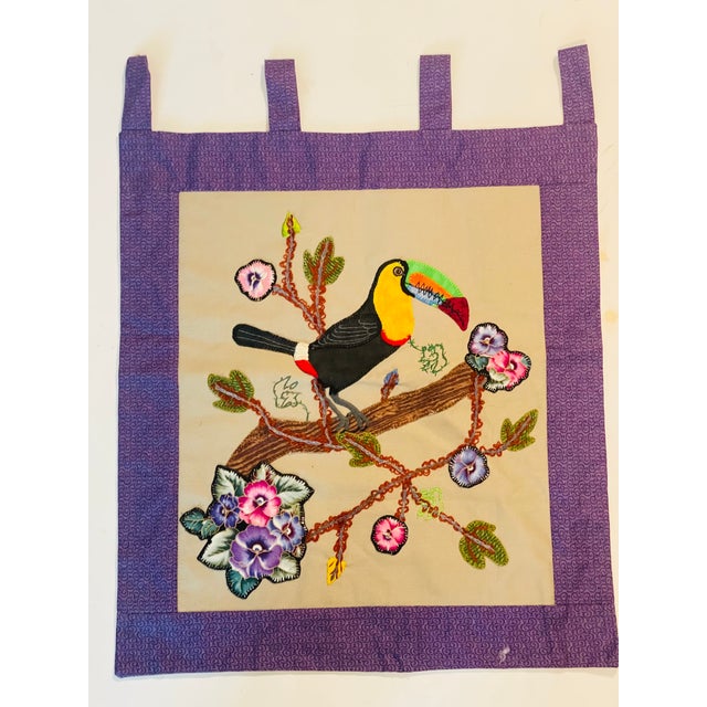 Beautiful colourful vintage handmade textile art from Costa Rica folk art of a toucan bird and Floweers.in purple border.