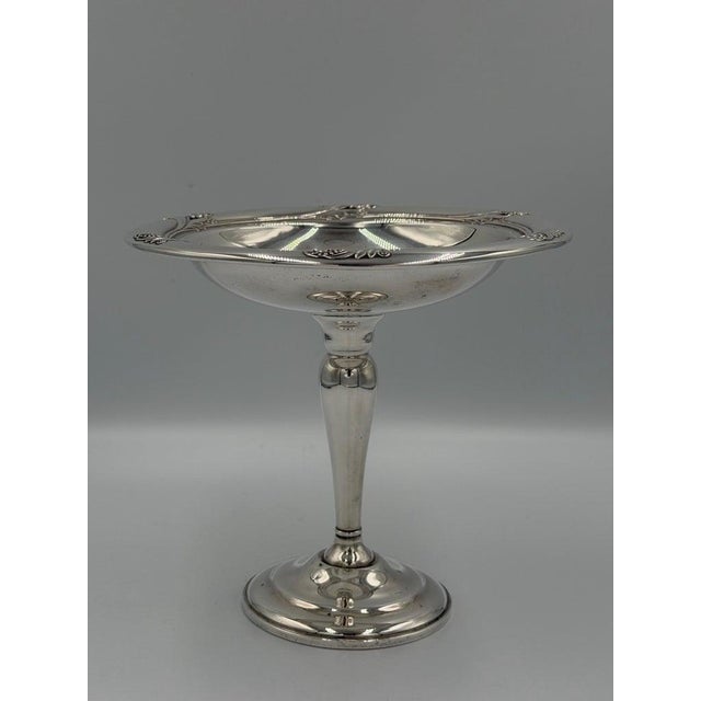 This elegant antique pedestal compote, crafted in sterling silver, exemplifies refined classical design through its...