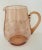 A pink depression glass pitcher with lightly faceted sides and etchings of flowers and leaves. Made to hold your water or...