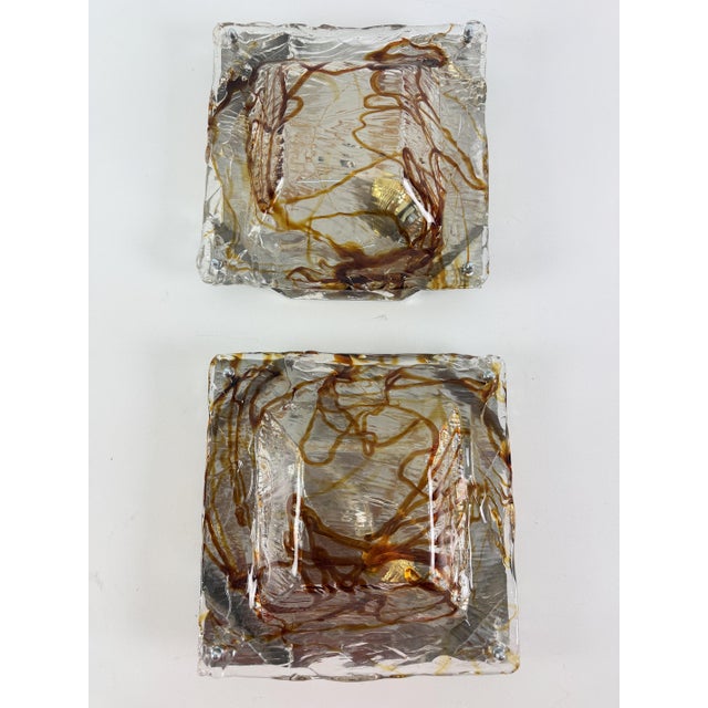 Set of two Murano glass wall lamps, 1970s Handcrafted Murano glass, characterized by a rough, frosted texture with...