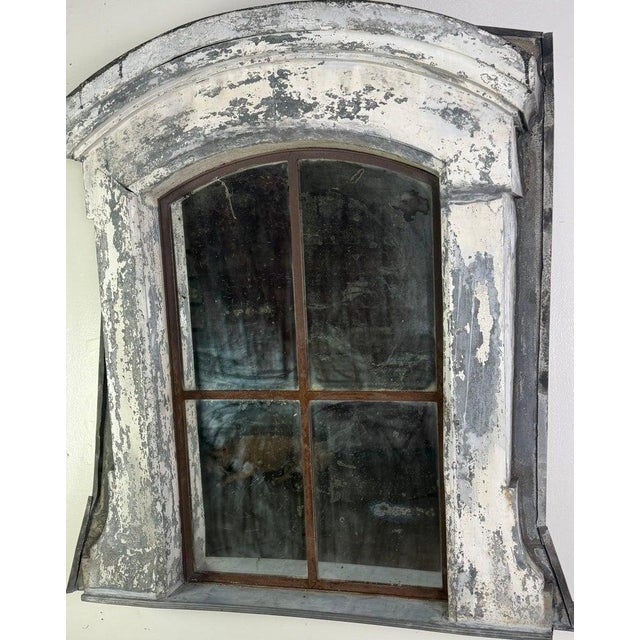 A striking architectural mirror fashioned from an antique dormer window frame, exuding authentic European charm and a...