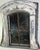 A striking architectural mirror fashioned from an antique dormer window frame, exuding authentic European charm and a...