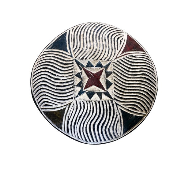A hand-carved shield from the Bamileke people of Cameroon, hand carved from a single piece of wood. This striking round...