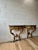 A striking pair of Rococo Revival wall consoles featuring richly carved scrolling acanthus foliage, shell motifs, and...