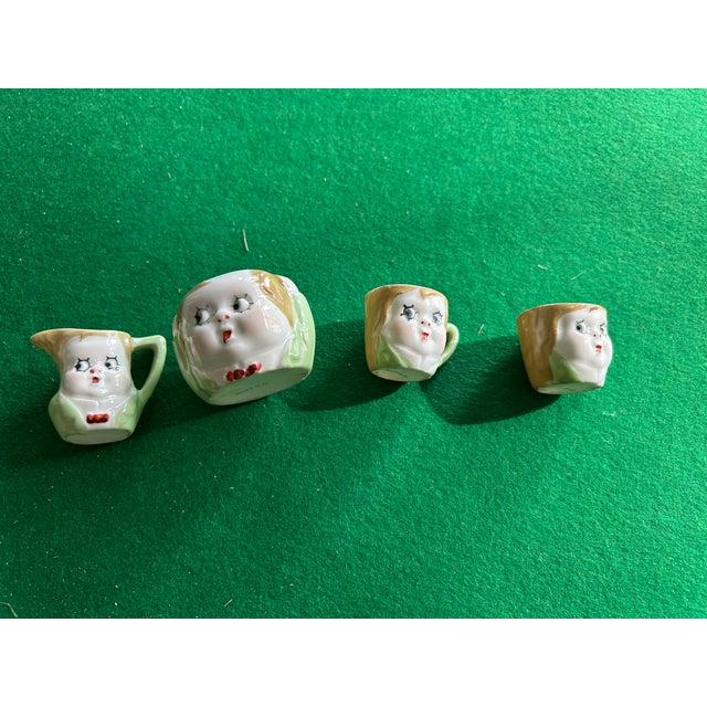 Cute child's tea set from Japan: 2 cups, 3 saucers, a creamer and sugar bowl in a Kewpie Doll design. Hand painted.