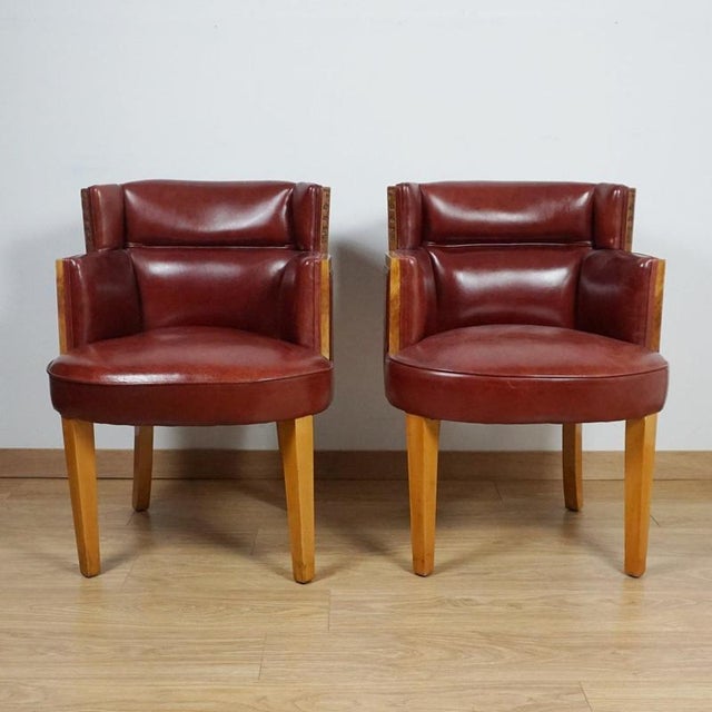 A pair of art deco armchairs by harry & lou epstein. Burr walnut veneered with carved detail to arms. Chestnut leather re-...