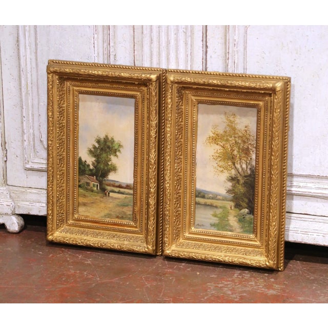 This refined pair of antique French pendant landscape paintings, executed circa 1870, is painted in oil on wood panel and...