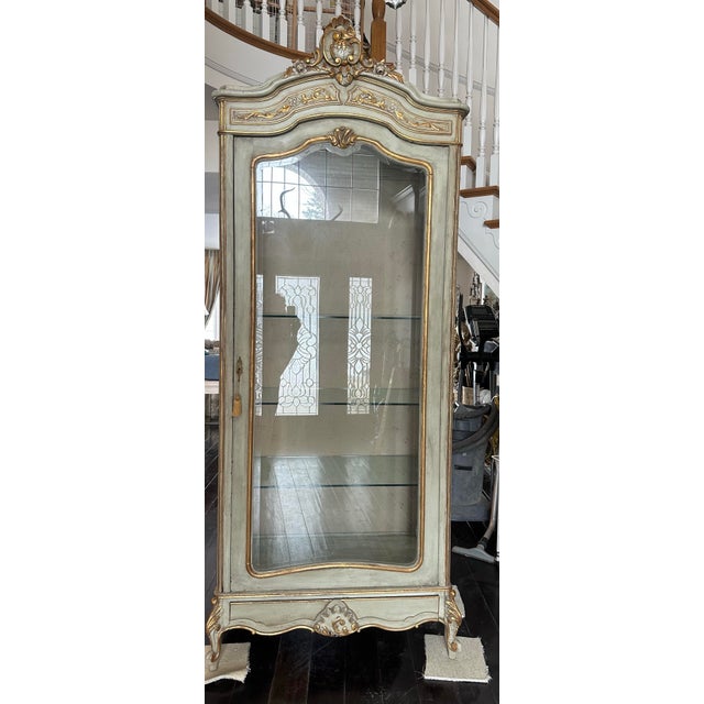 19th Century Louis XVI single door display cabinets Pale, pale green with gold accents. Cabriole legs, carved top crest,...