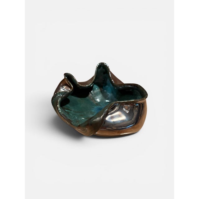 A glazed ceramic bowl by Gene Farkus, formed in an organic freeform shape with a folded, undulating rim. The interior is...